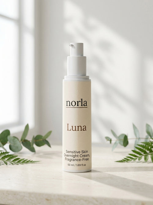 Luna Sensitive Skin Overnight Cream 50 ml by Norla, airless pump bottle on a marble surface with eucalyptus and fern