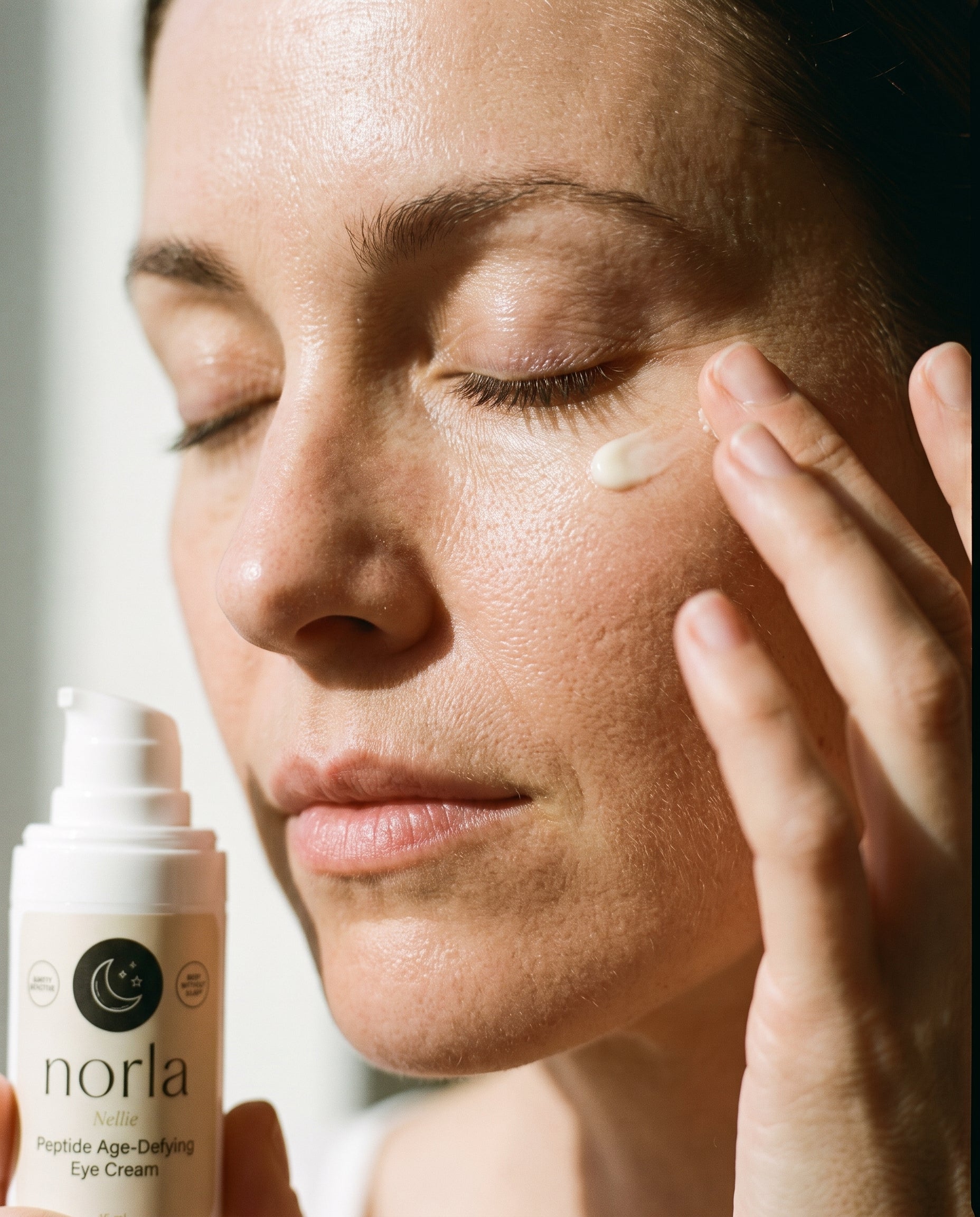 Applying Norla Nellie eye cream along the orbital bone with the ring finger